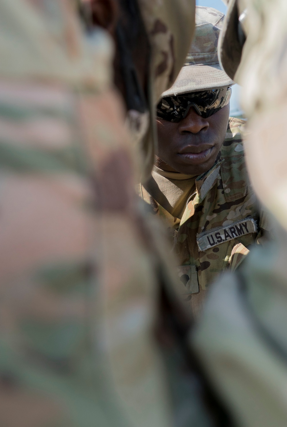 A Soldier Works with Teammates to Disassemble Fuel Lines