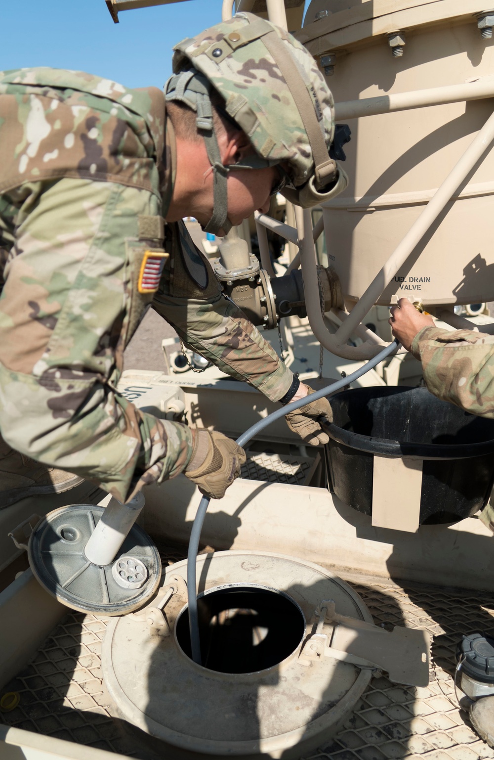 A Soldier Drains a Fuel Drum into a Fuel Tank