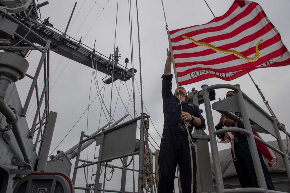 Quartermaster 3rd Class Bradley Kobernik, left, and Quartermaster 3rd Class Danaril Mojet raise the Union Jack aboard USS John C. Stennis (CVN 74).