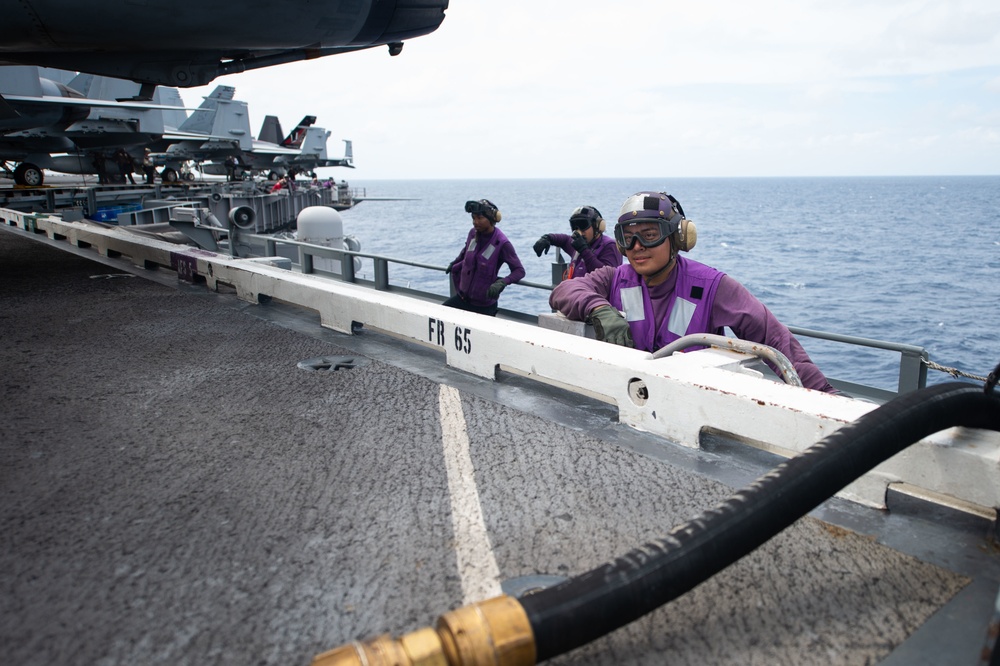 Sailors observe a fueling evolution on the flight deck aboard the Nimitz-class aircraft carrier USS John C. Stennis (CVN 74).