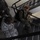 Maryland Guard, Bosnia-Herzegovina armed forces celebrate 15-year partnership The image shows multiple military personnel in a stairwell, wearing different camouflage uniforms. At least three individuals are visible: one in Air Force digital tiger-stripe ABU pattern, one in Army/OCP multicam pattern carrying a backpack, and one in what appears to be Marine MARPAT pattern. The overhead angle provides a top-down perspective of the stairwell scene.