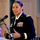 Maryland Guard, Bosnia-Herzegovina armed forces celebrate 15-year partnership A female U.S. Army officer in dress blues is delivering a speech at a podium with a microphone. She is wearing multiple service ribbons and medals on her uniform, indicating significant military experience and rank. The setting appears to be a formal indoor ceremony or event.