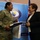 Maryland Guard, Bosnia-Herzegovina armed forces celebrate 15-year partnership A U.S. Army soldier in multicam/OCP uniform is exchanging items with a civilian woman in a black blazer during what appears to be an official meeting or ceremony. The backdrop displays the Bosnia and Herzegovina Ministry of Defence logo and website (www.mod.gov.ba), indicating this is an official bilateral military or diplomatic engagement. Both individuals are smiling, suggesting a positive and cordial interaction.