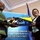 Maryland Guard, Bosnia-Herzegovina armed forces celebrate 15-year partnership A U.S. Army soldier in multicam uniform and a civilian woman in formal attire are jointly holding a commemorative plaque or award at an official ceremony. The event appears to take place at the Bosnia and Herzegovina Ministry of Defence, as indicated by the banner in the background. The plaque features the Bosnian flag design and text referencing 'Continued Cooperation, Support, & Friendship.'