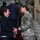 Maryland Guard, Bosnia-Herzegovina armed forces celebrate 15-year partnership A formal meeting or reception is taking place in what appears to be an official building with a grand staircase. A civilian woman in a black suit is shaking hands with a female U.S. military officer in OCP (Operational Camouflage Pattern) uniform. Multiple other military personnel and civilians are visible in the background ascending the red-carpeted staircase.