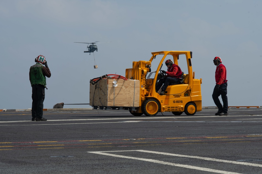 Sailors conduct an ammunition onload on the flight deck during a vertical replenishment aboard the Nimitz-class aircraft carrier USS John C. Stennis (CVN 74).