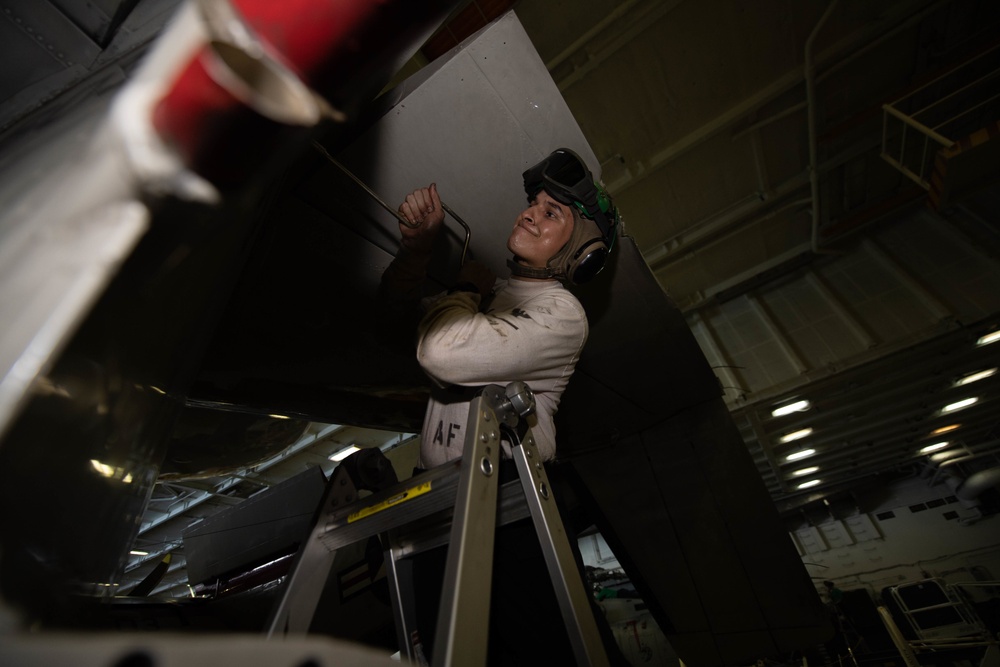 U.S. Navy Sailor conduct maintenance on an E-2C Hawkeye