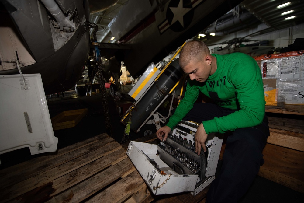 U.S. Navy Sailor conducts maintenance on an E-2C Hawkeye