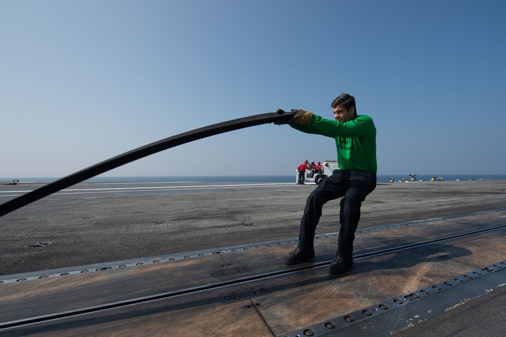 U.S. Navy Sailor places slot seal on steam-powered catapult