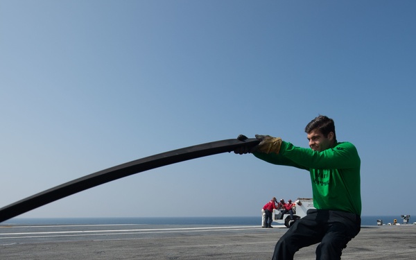 U.S. Navy Sailor places slot seal on steam-powered catapult