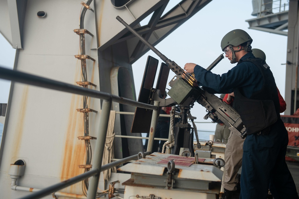 Airman Apprentice Tyler Brown, from Stockton, California, reloads a .50-caliber machine gun on the fantail aboard the Nimitz-class aircraft carrier USS John C. Stennis (CVN 74).