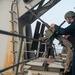 Airman Apprentice Tyler Brown, from Stockton, California, reloads a .50-caliber machine gun on the fantail aboard the Nimitz-class aircraft carrier USS John C. Stennis (CVN 74).