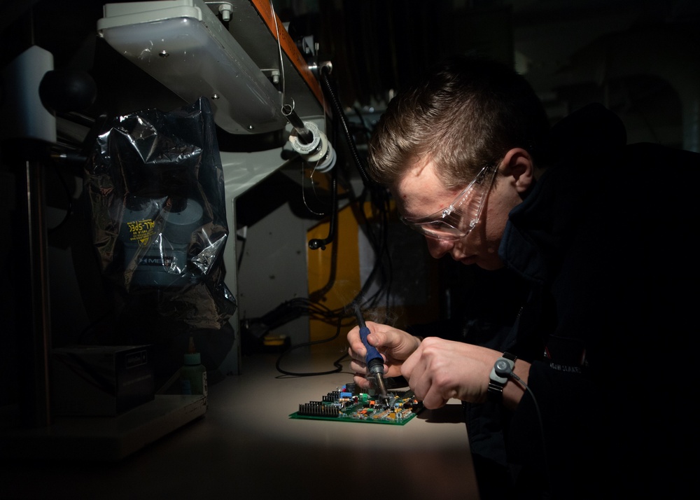 Aviation Electronics Technician Airman Adam Slakes, from Holland, Michigan, replaces components on a circuit board aboard the Nimitz-class aircraft carrier USS John C. Stennis (CVN 74).