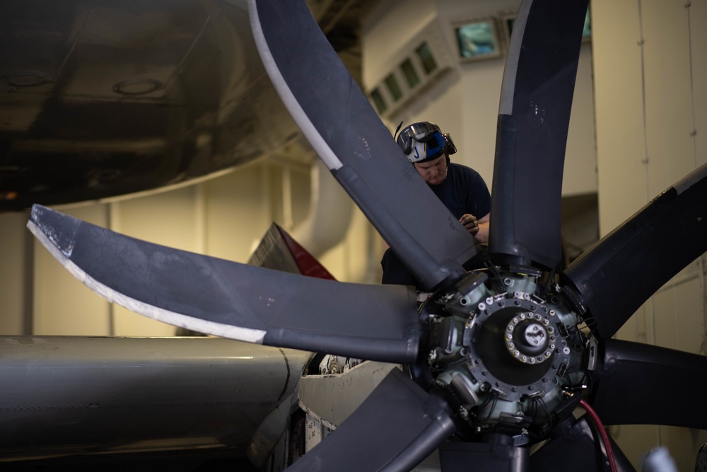 U.S. Navy Sailor conducts maintenance on an E-2C Hawkeye