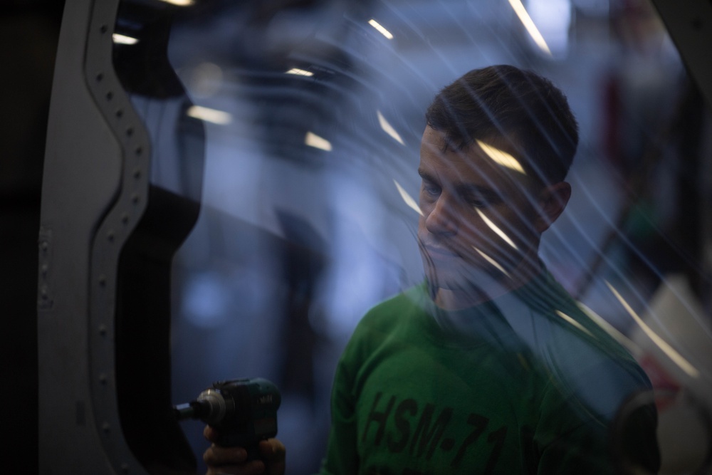 U.S. Navy Sailor conducts maintenance on an MH-60R Sea Hawk