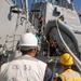 Sailors lower a RHIB aboard USS Mobile Bay