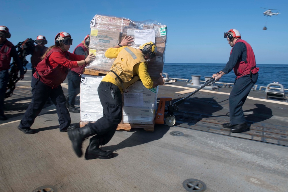 U.S. Navy Sailors move supplies from the flight deck of the guided-missile destroyer USS Spruance (DDG 111)