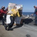 U.S. Navy Sailors move supplies from the flight deck of the guided-missile destroyer USS Spruance (DDG 111)