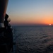 The guided-missile cruiser USS Mobile Bay (CG 53) transits towards a setting sun in the Indian Ocean