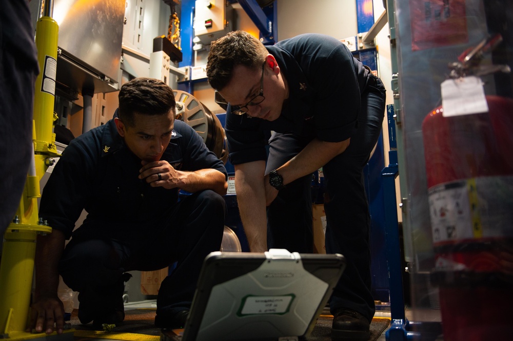U.S. Sailors check diagrams