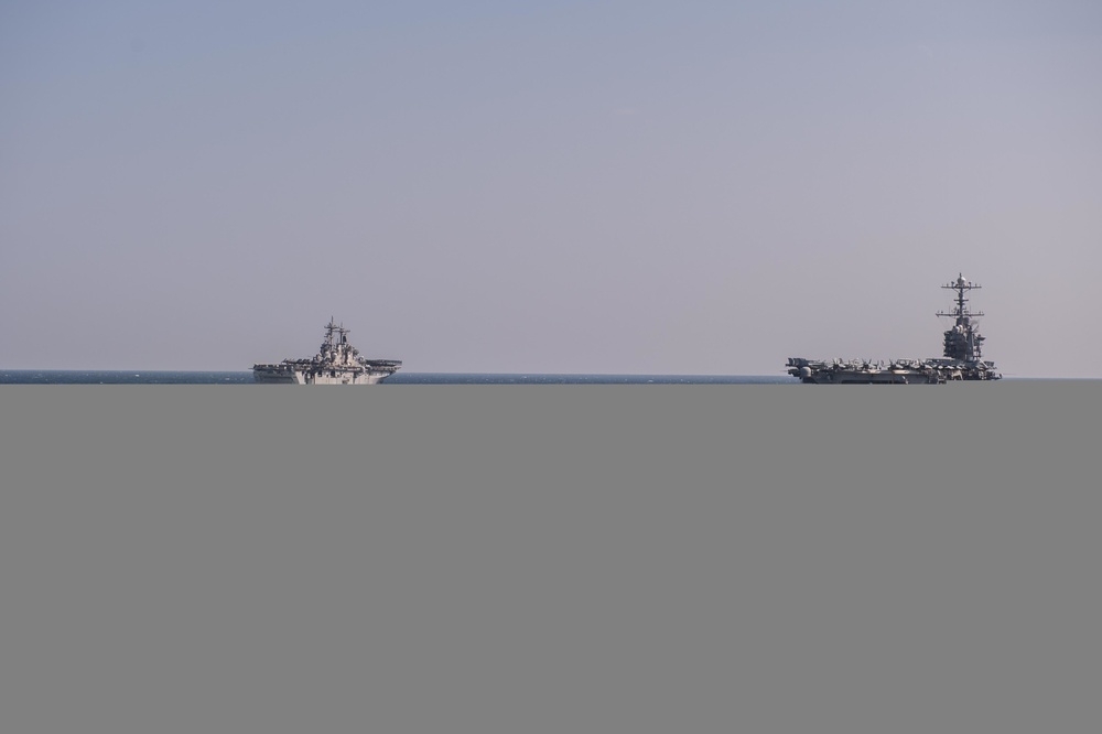 The amphibious assault ship USS Essex (LHD 2) and the aircraft carrier USS John C. Stennis (CVN 74)