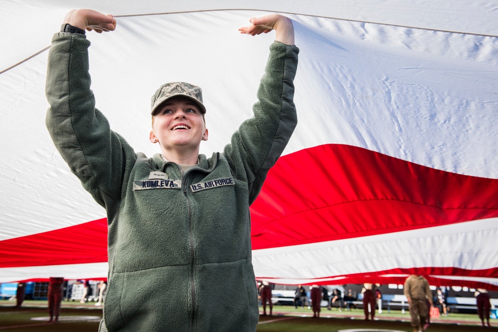 Nellis, Creech Airmen wave half-ton American flag for Las Vegas Bowl