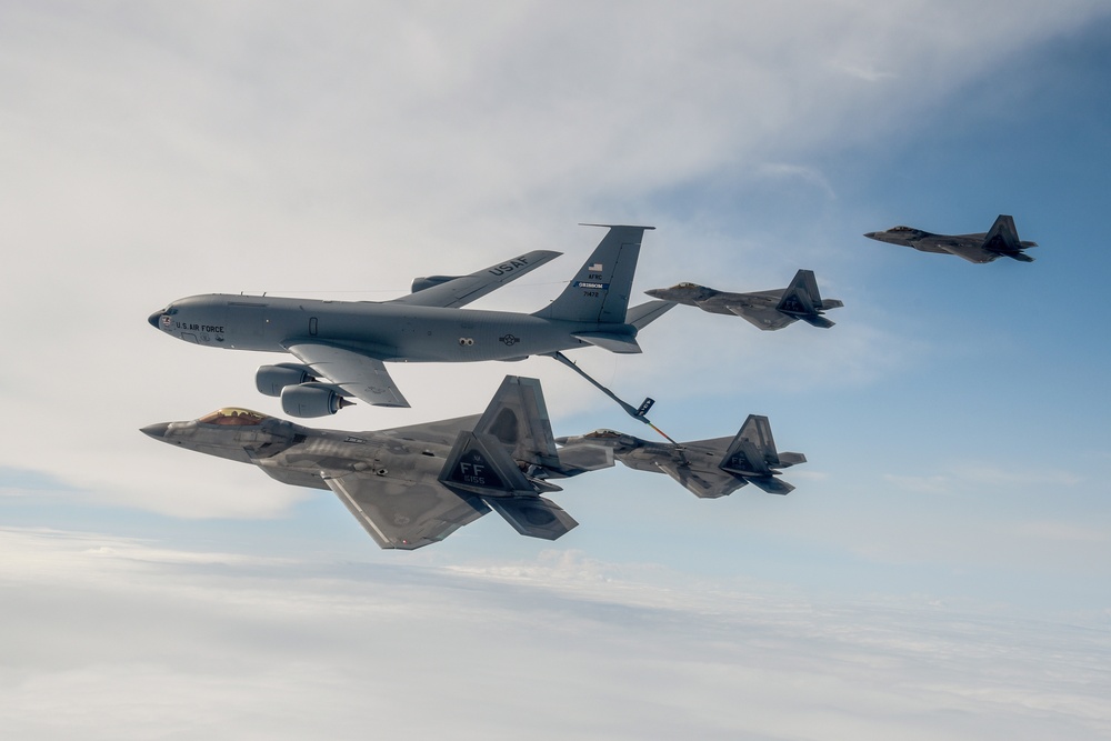 KC-135 Stratotanker and F-22 Raptors conduct aerial refueling
