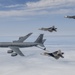 KC-135 Stratotanker and F-22 Raptors prepare to conduct aerial refueling