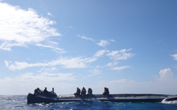 Coast Guard Cutter Campbell crew with suspected drug smuggling boat