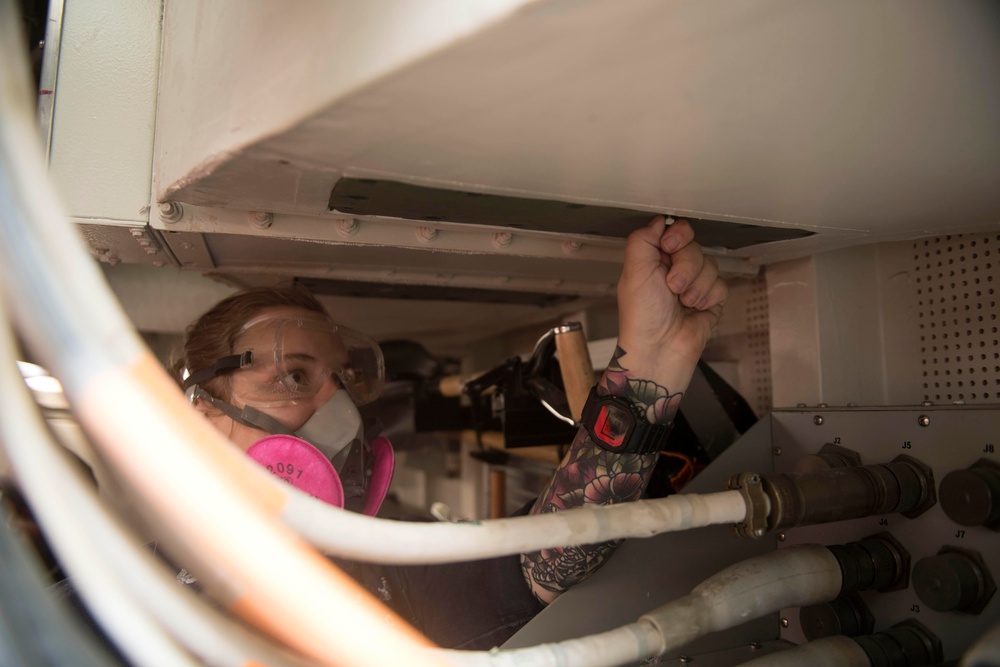 U.S. Navy Damage Controlman 3rd Class Jessica Kehling, from Hamilton, Ohio, performs maintenance in a repair locker aboard the guided-missile destroyer USS Spruance (DDG 111)