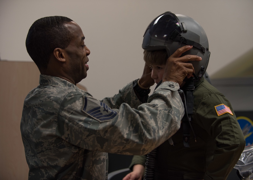 Airman places helmet on Brian Rubio's head during pilot for a day tour