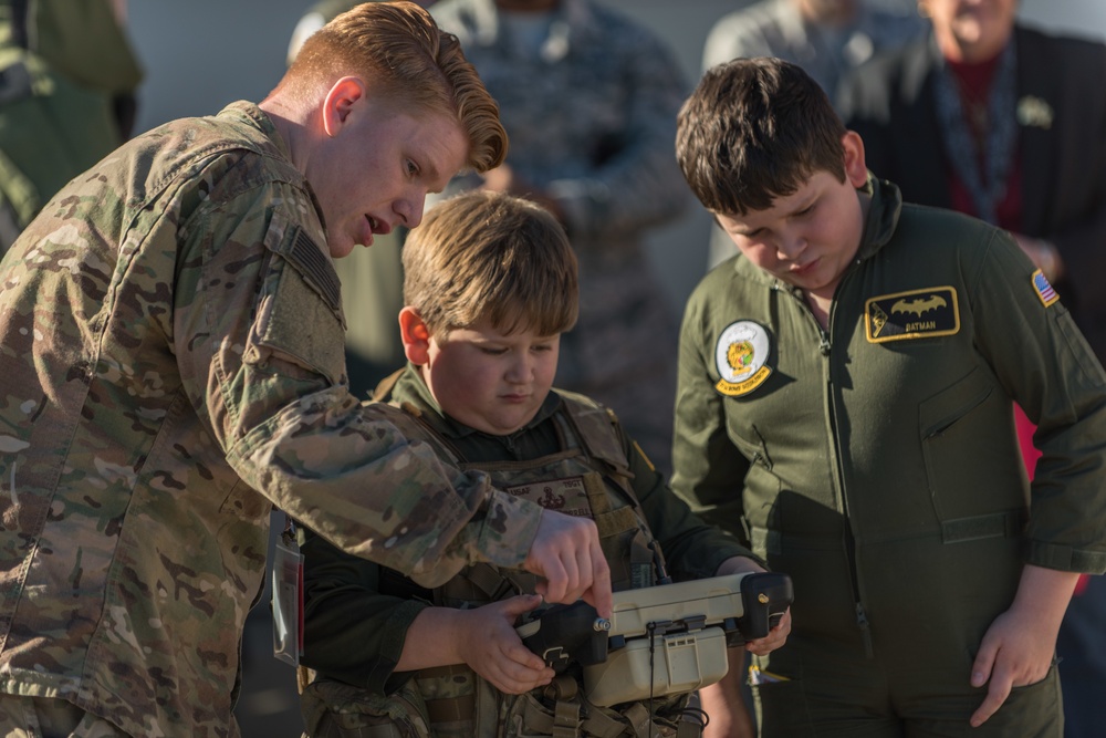 Airman shows brothers how to use EOD robot during pilot for a day program