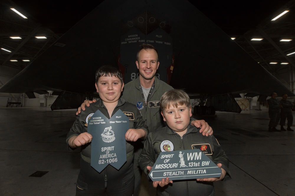 Ziegler poses with brothers Brian and Ethan Rubio in front of the B-2 Spirit Stealth Bomber