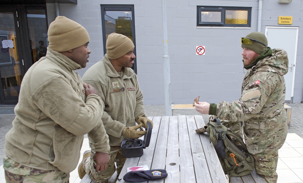 Senior Master Sgt. Aaron Doss, left, and Tech. Sgt. Gregory Myers, trade patches with a Danish soldier