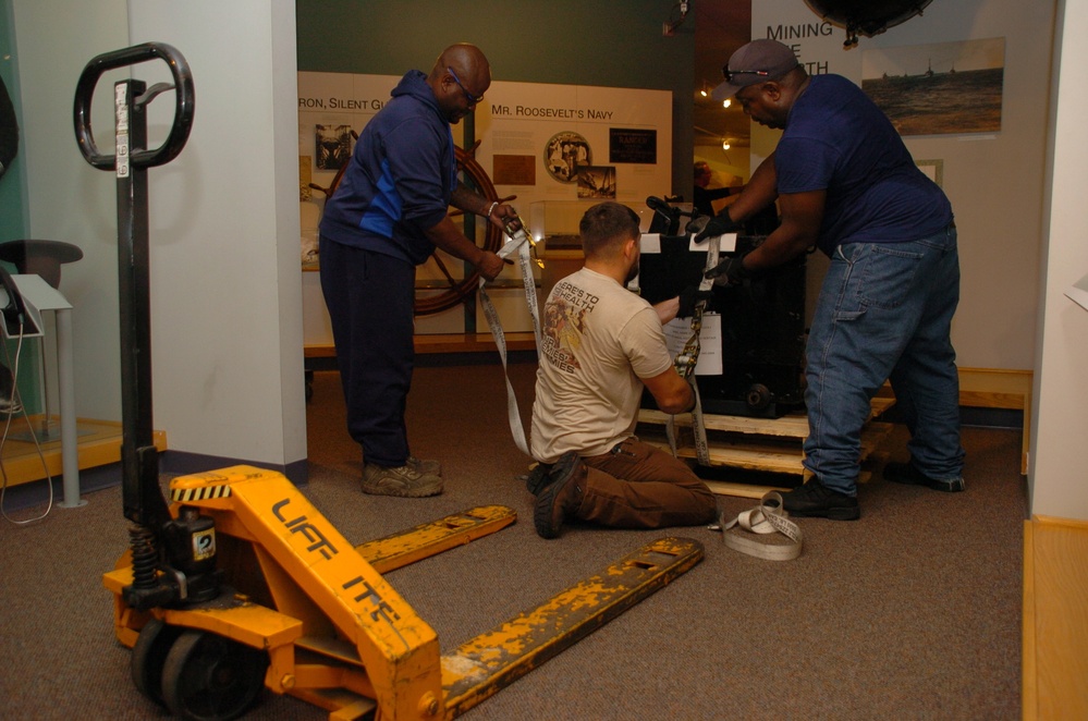 DLA Staff members carefully move Naval Museum's larger artifacts