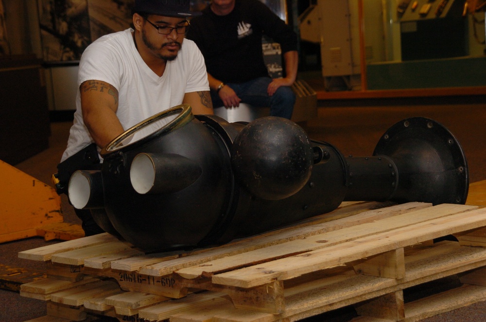DLA staff members carefully move Naval Museum's larger artifacts
