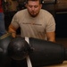 DLA staff members carefully move Naval Museum's larger artifacts