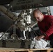U.S. Sailor cleans bomb ejector rack in the hangar bay