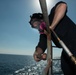 U.S. Sailor grinds away rust on railing