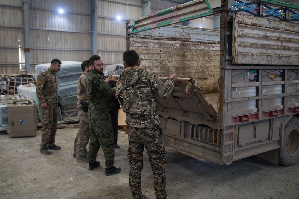 Coalition Forces members distribute pallets of medical supplies to SDF, local doctors