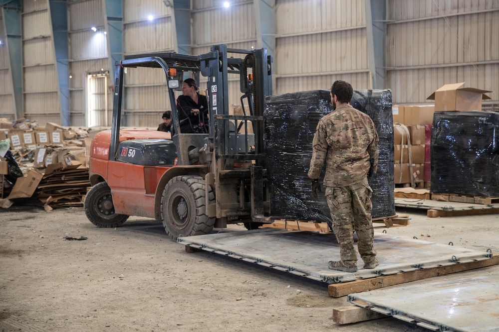 Coalition Forces members distribute pallets of medical supplies to SDF, local doctors