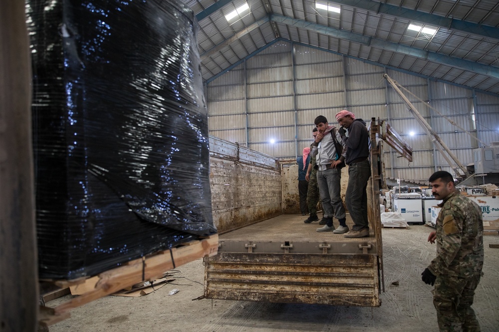 Coalition Forces members distribute pallets of medical supplies to SDF, local doctors