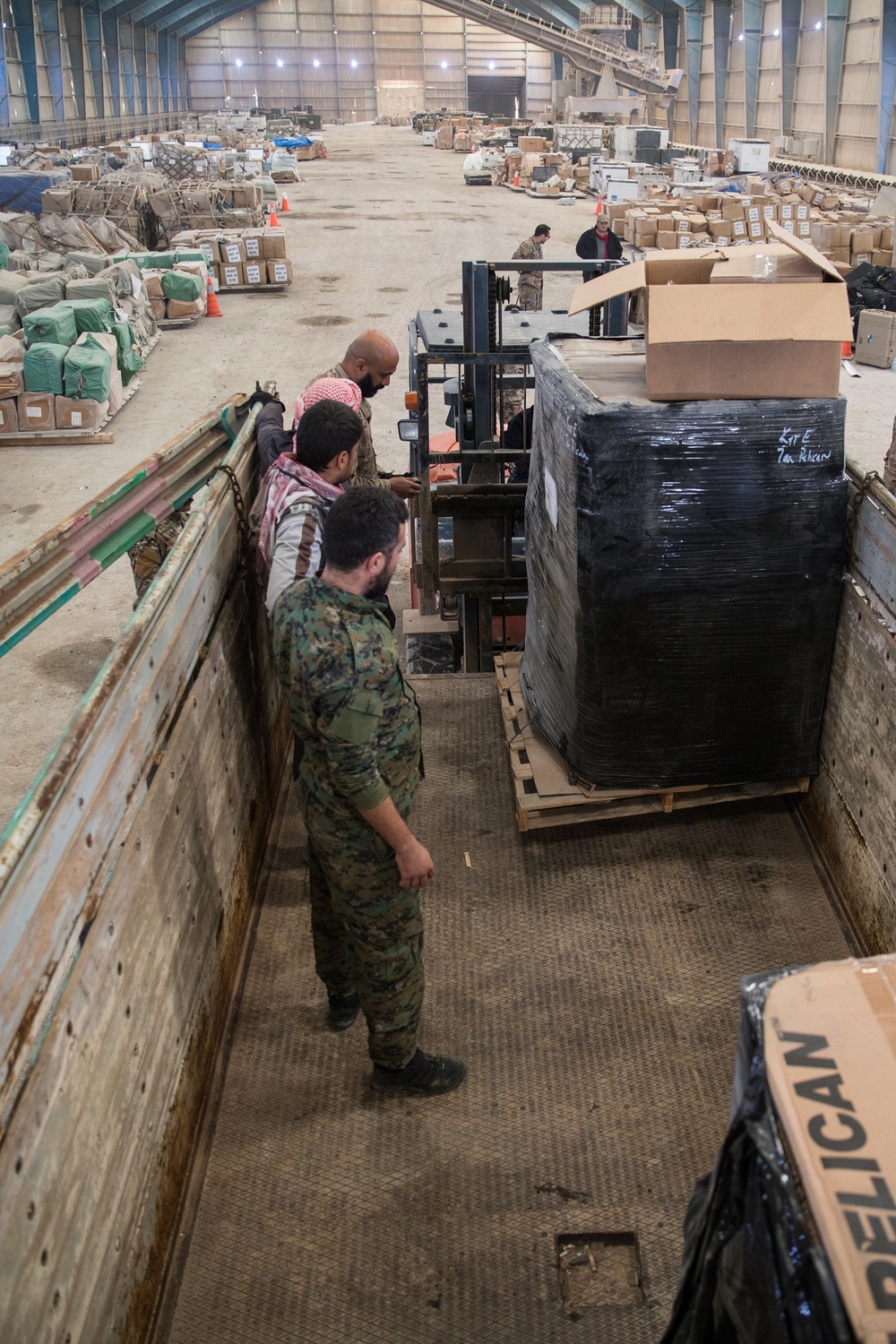 Coalition Forces members distribute pallets of medical supplies to SDF, local doctors