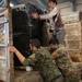Coalition Forces members distribute pallets of medical supplies to SDF, local doctors