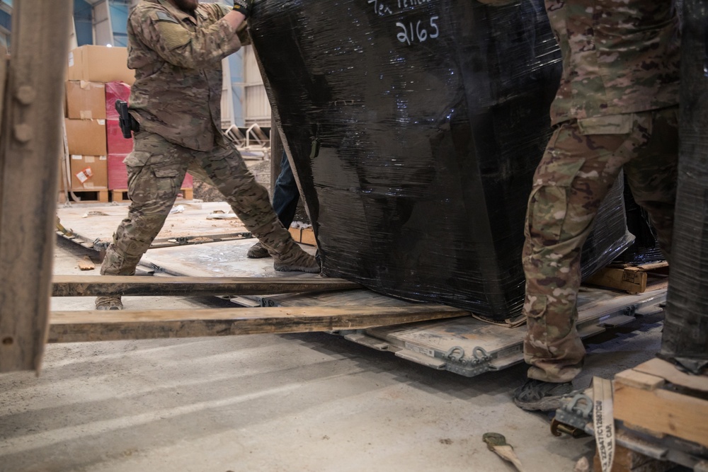 Coalition Forces members distribute pallets of medical supplies to SDF, local doctors
