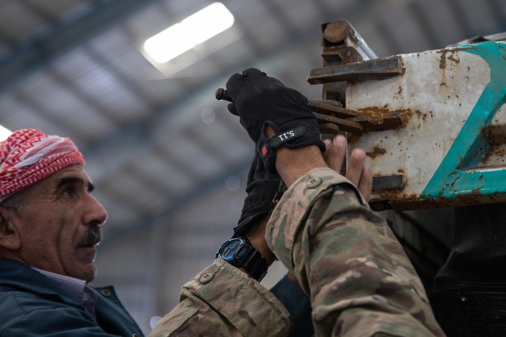 Coalition Forces members distribute pallets of medical supplies to SDF, local doctors