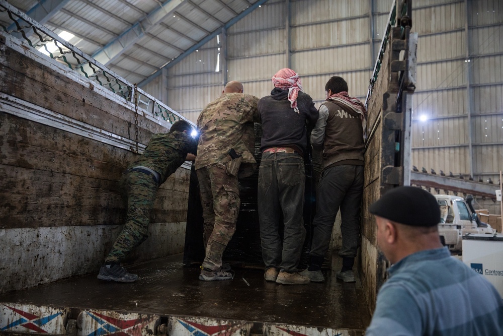 Coalition Forces members distribute pallets of medical supplies to SDF, local doctors