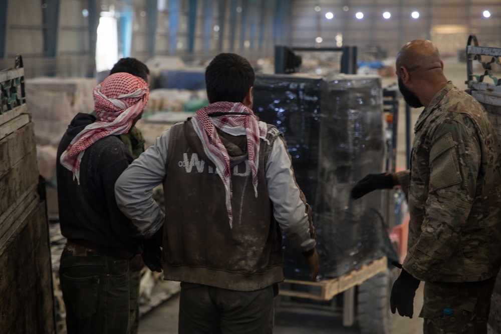 Coalition Forces members distribute pallets of medical supplies to SDF, local doctors