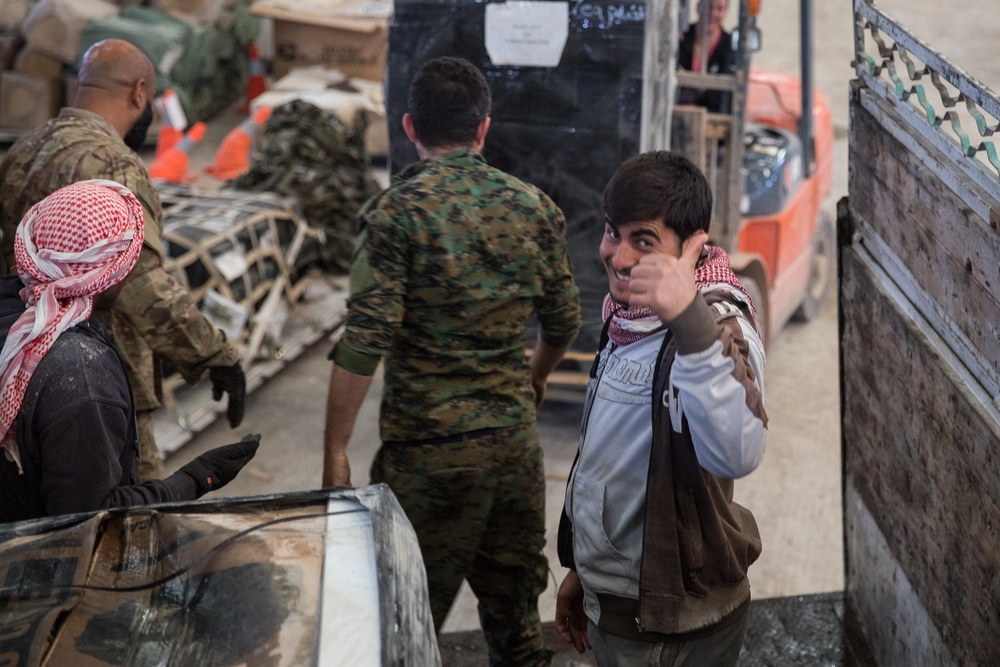 Coalition Forces members distribute pallets of medical supplies to SDF, local doctors