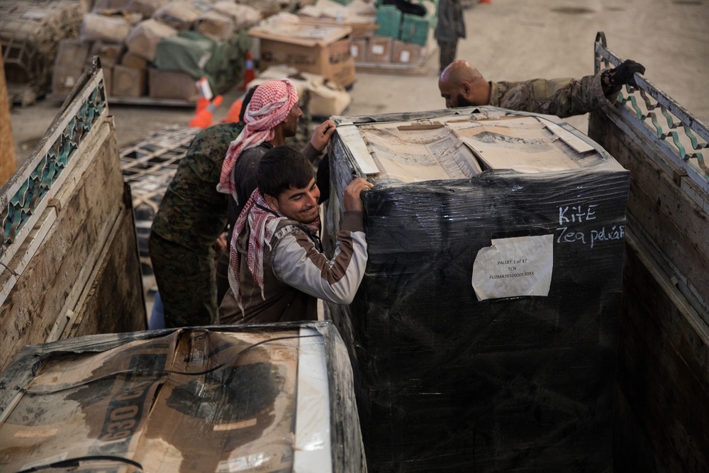 Coalition Forces members distribute pallets of medical supplies to SDF, local doctors